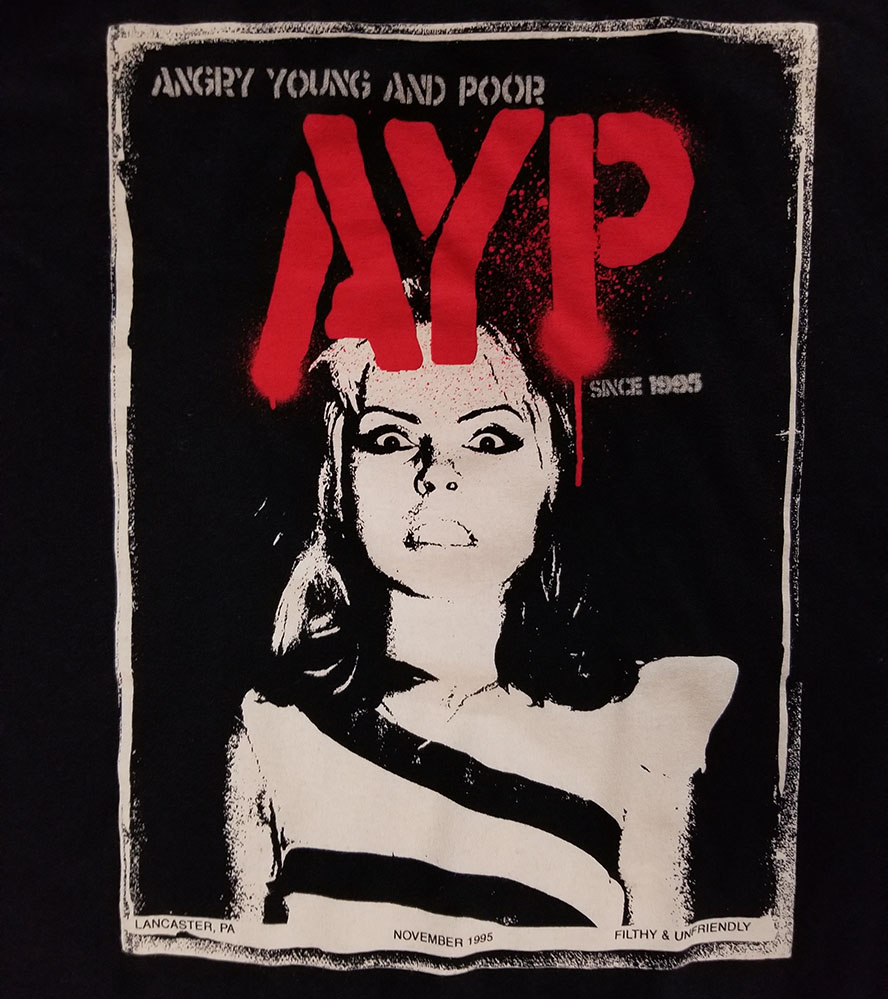 Angry Young And Poor- Debbie on a black ringspun cotton shirt